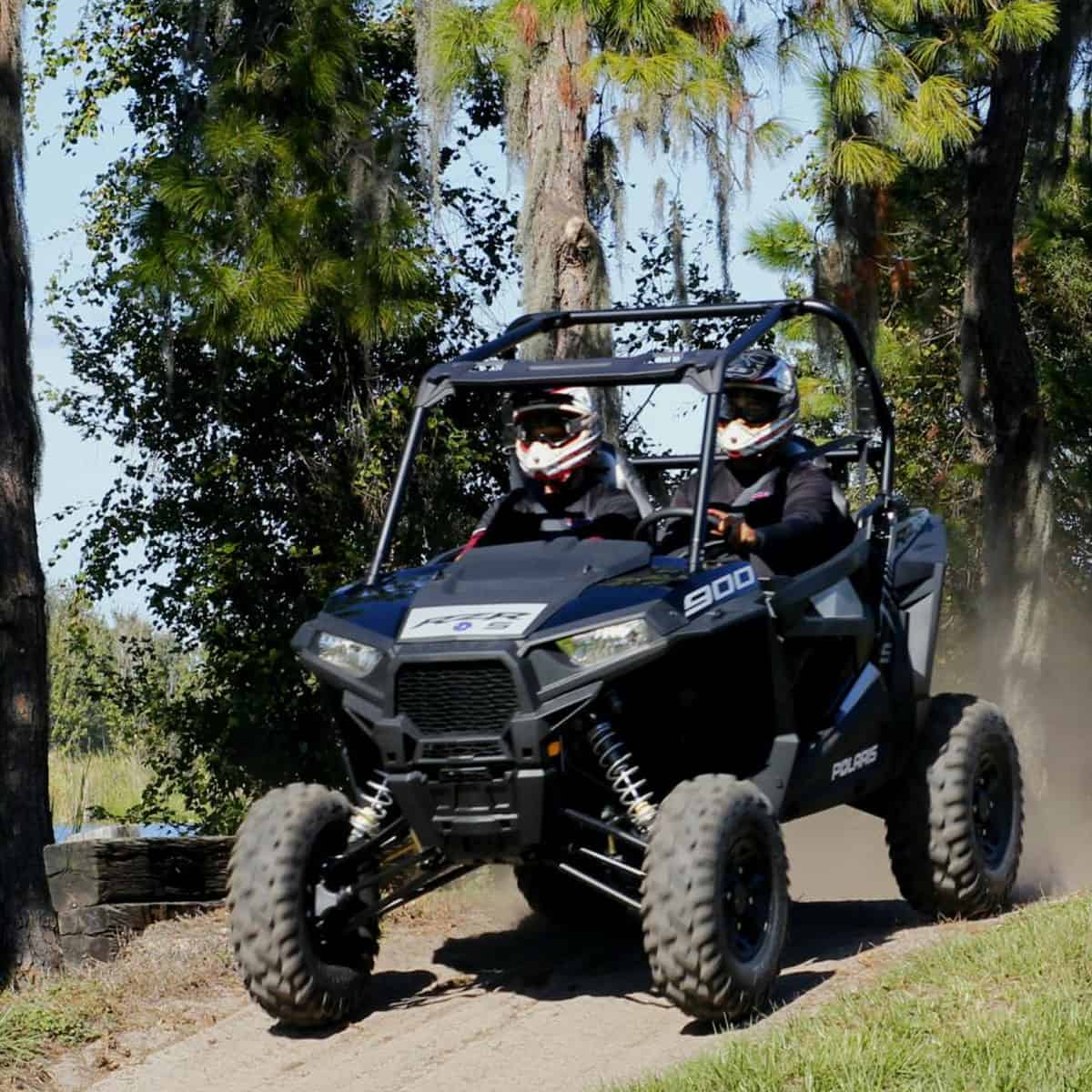 ATV driving through a sandy trail surrounded by Florida pine forest